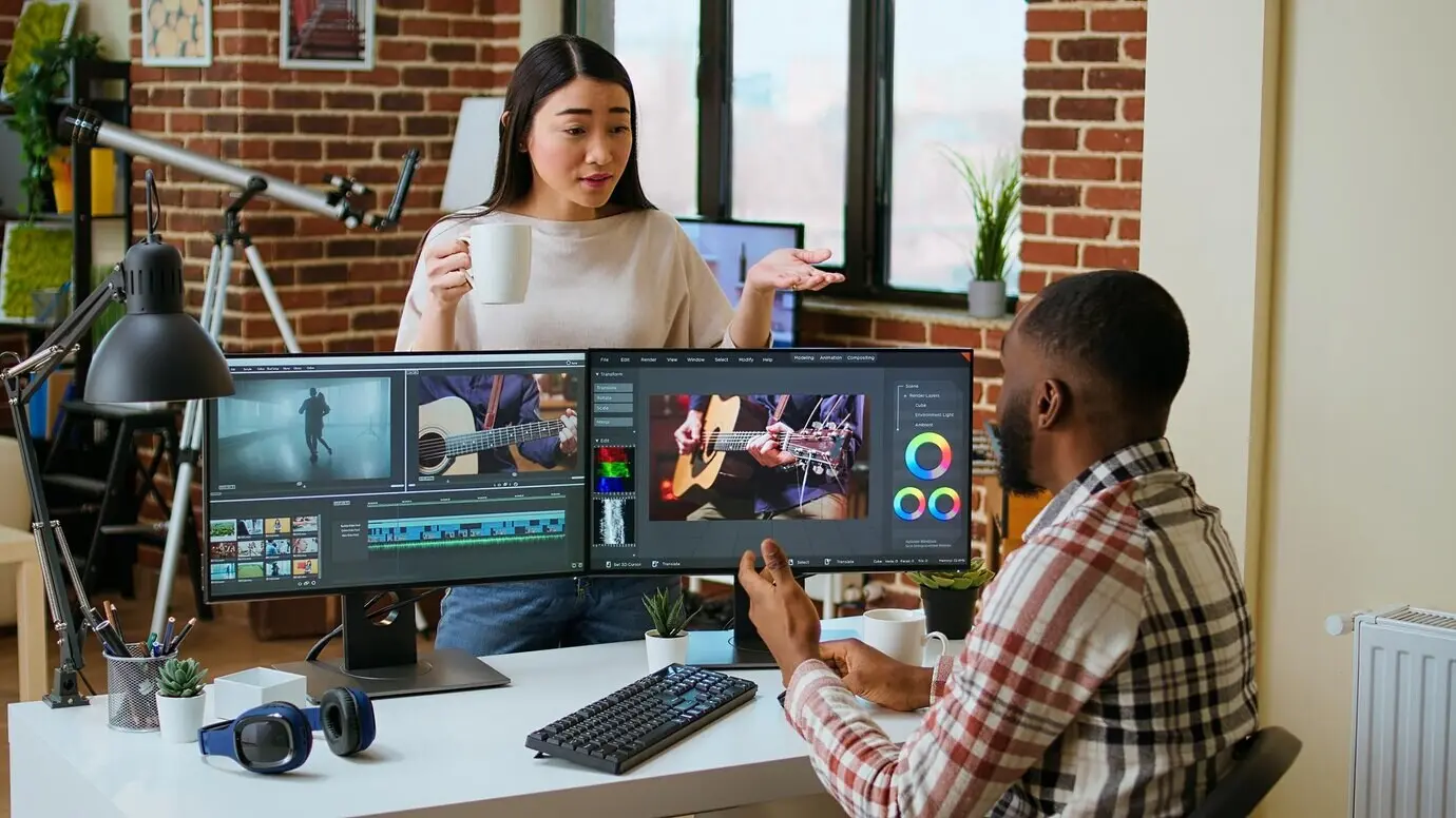 Interrassische Partner in einem kreativen Team, die gemeinsam an einem Videobearbeitungsprojekt arbeiten.